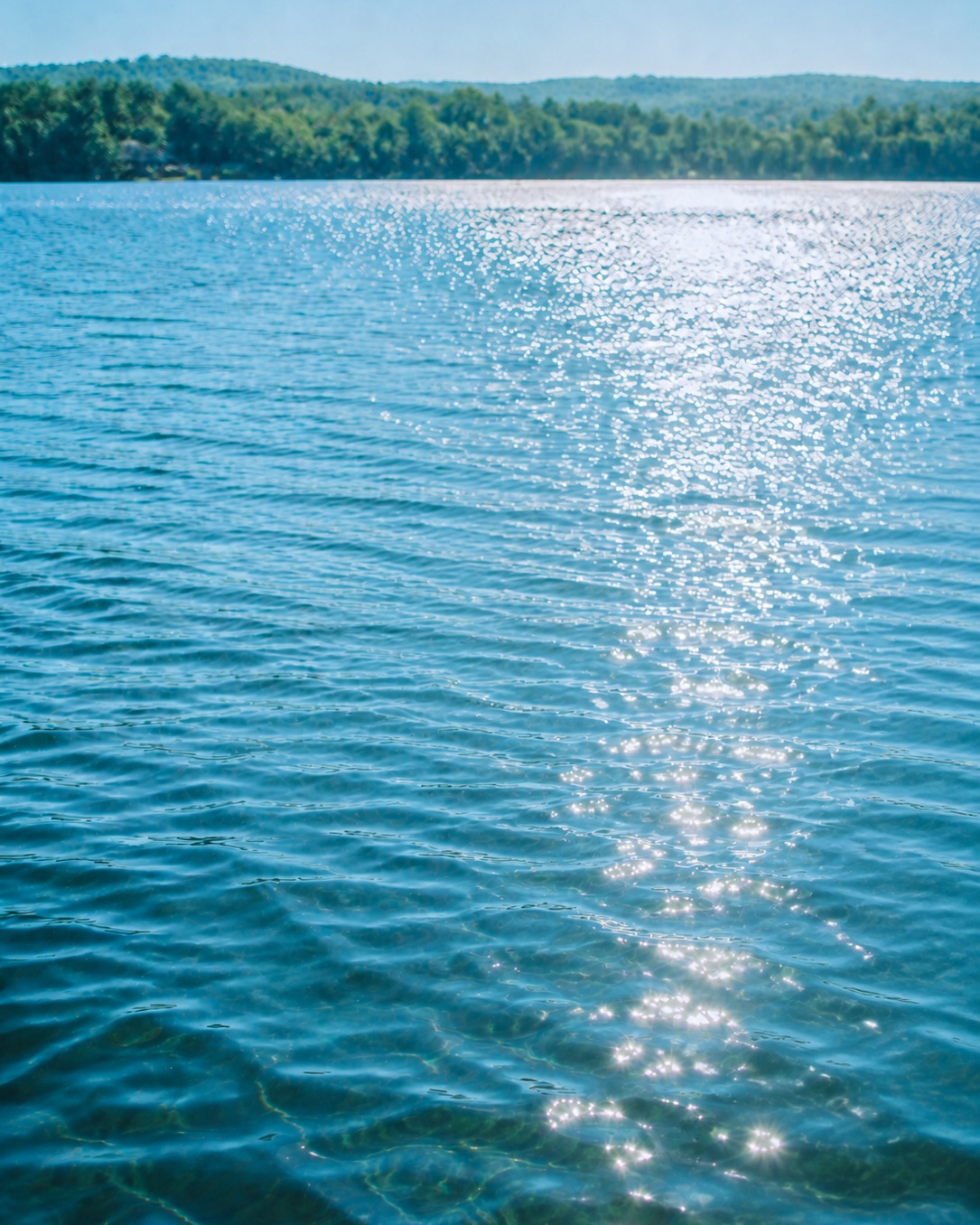 Sunlight sparkling across a clear lake